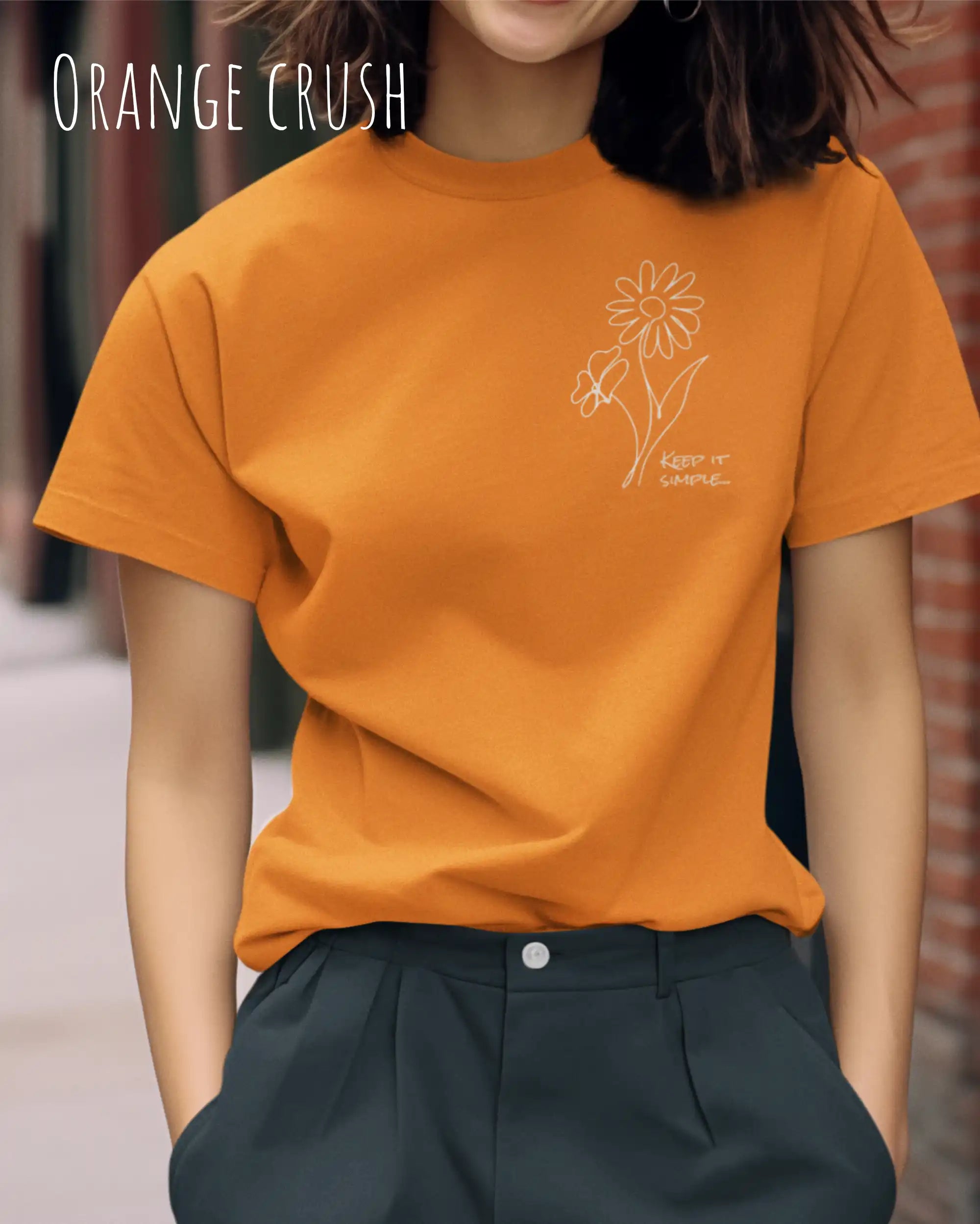 Junge Frau trägt ein design t-shirt in orange crush mit dem motiv keep it simple.