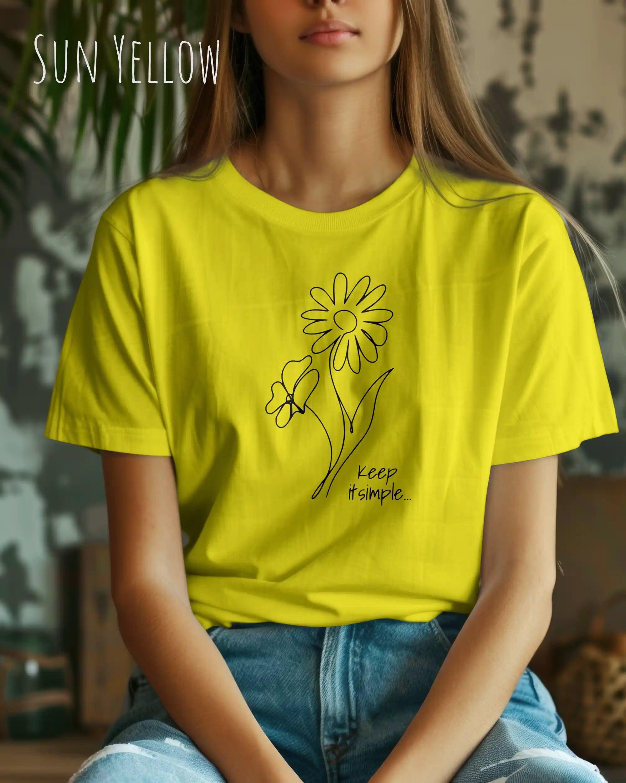Junge Frau trägt ein design t-shirt in sun yellow mit dem motiv keep it simple.