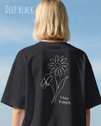 blonde frau trögt ein oversized heavyweight design-t-shirt in der farbe deep black und mit dem back print keep it simple.