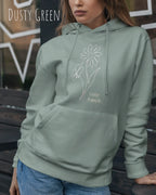 Frau trägt hoodie im feminine fit aus weicher baumwollmischung in farbe dusty green mit keep it simple motiv auf der Brust