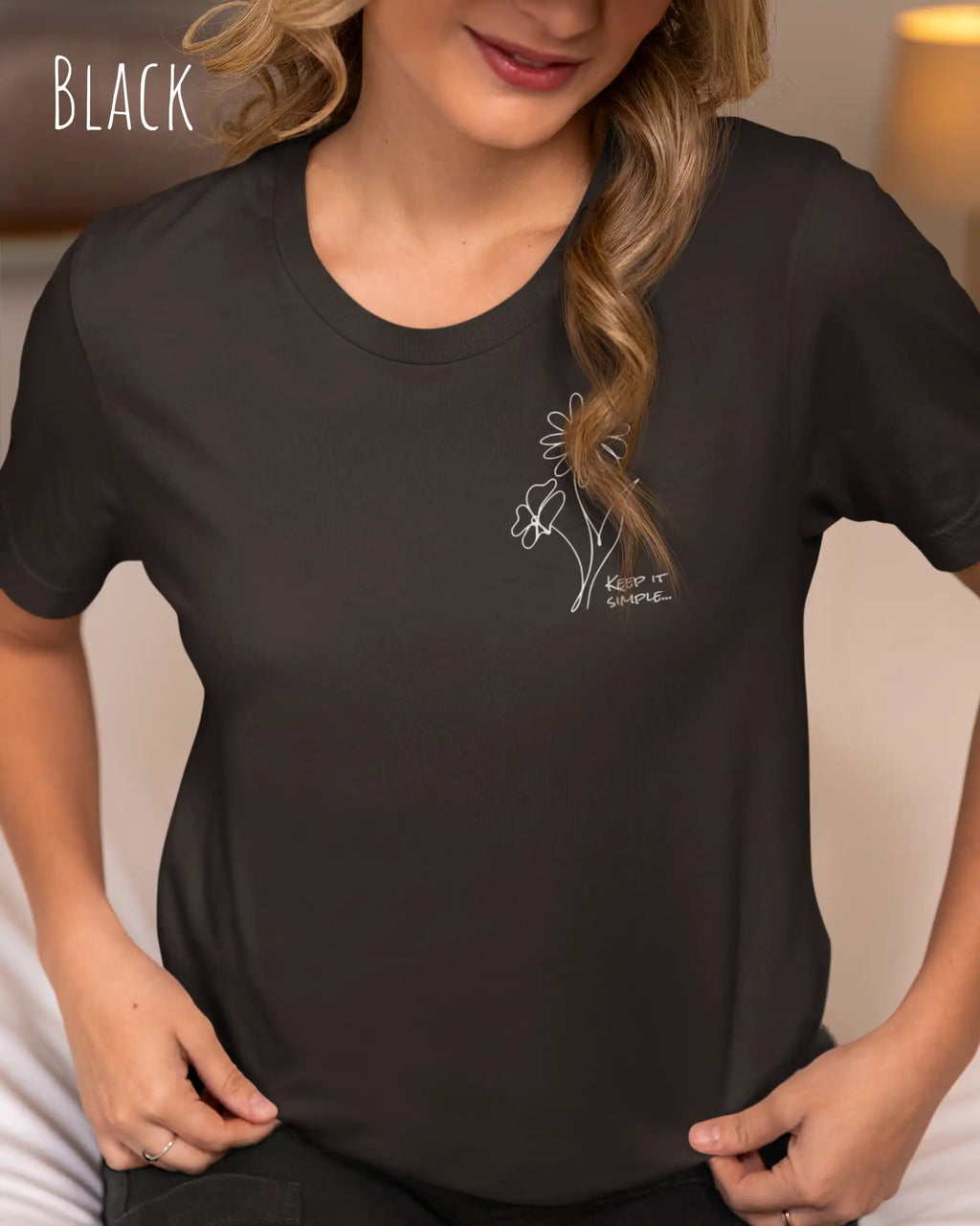 Das Bild zeigt eine junge frau, die ein design-t-shirt ind der farbe black mit dem grafik-motiv keeo it simple trägt.