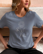 Das Bild zeigt eine junge frau, die ein design-t-shirt ind der farbe flint stone mit dem grafik-motiv keeo it simple trägt.