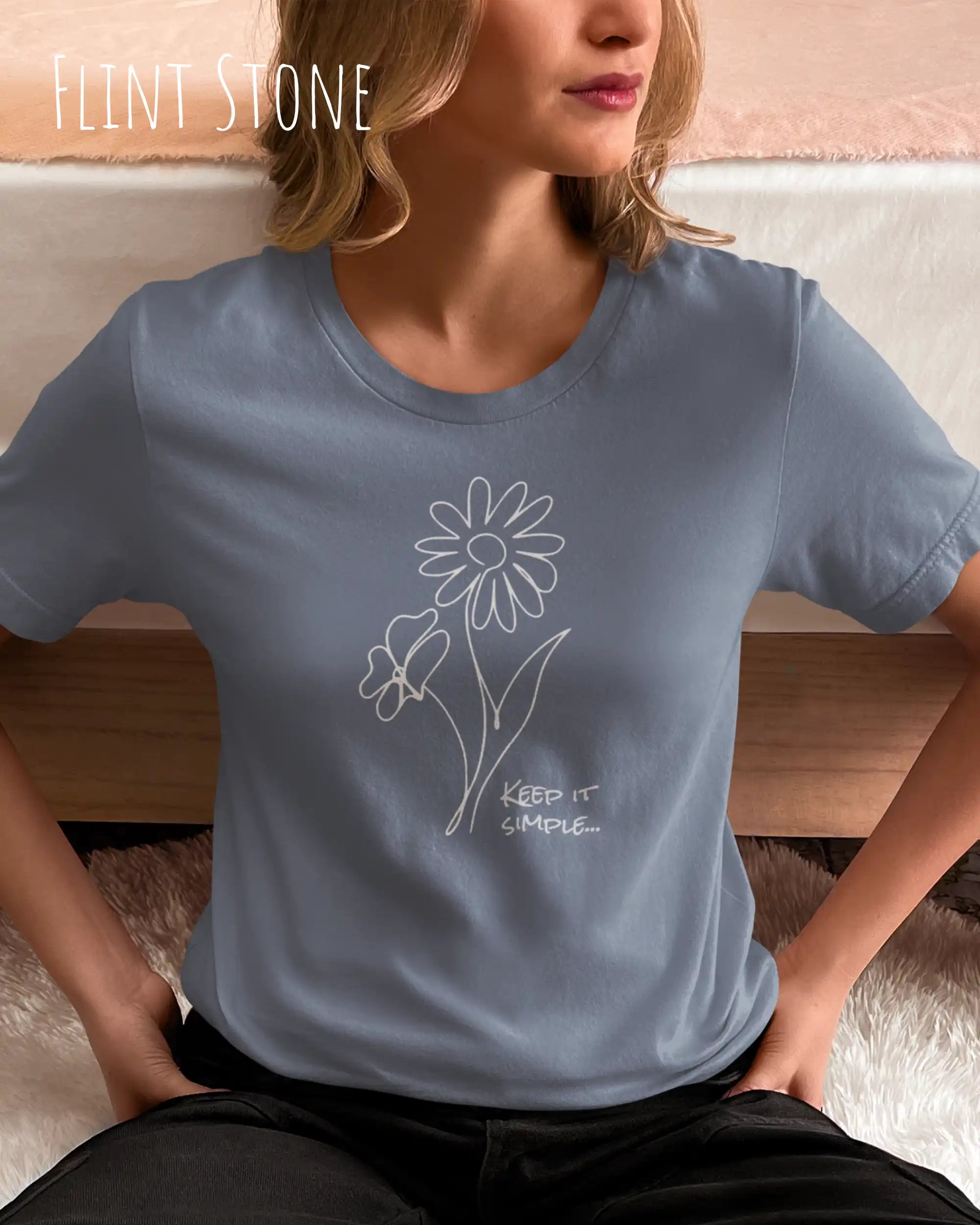 Das Bild zeigt eine junge frau, die ein design-t-shirt ind der farbe flint stone mit dem grafik-motiv keeo it simple trägt.