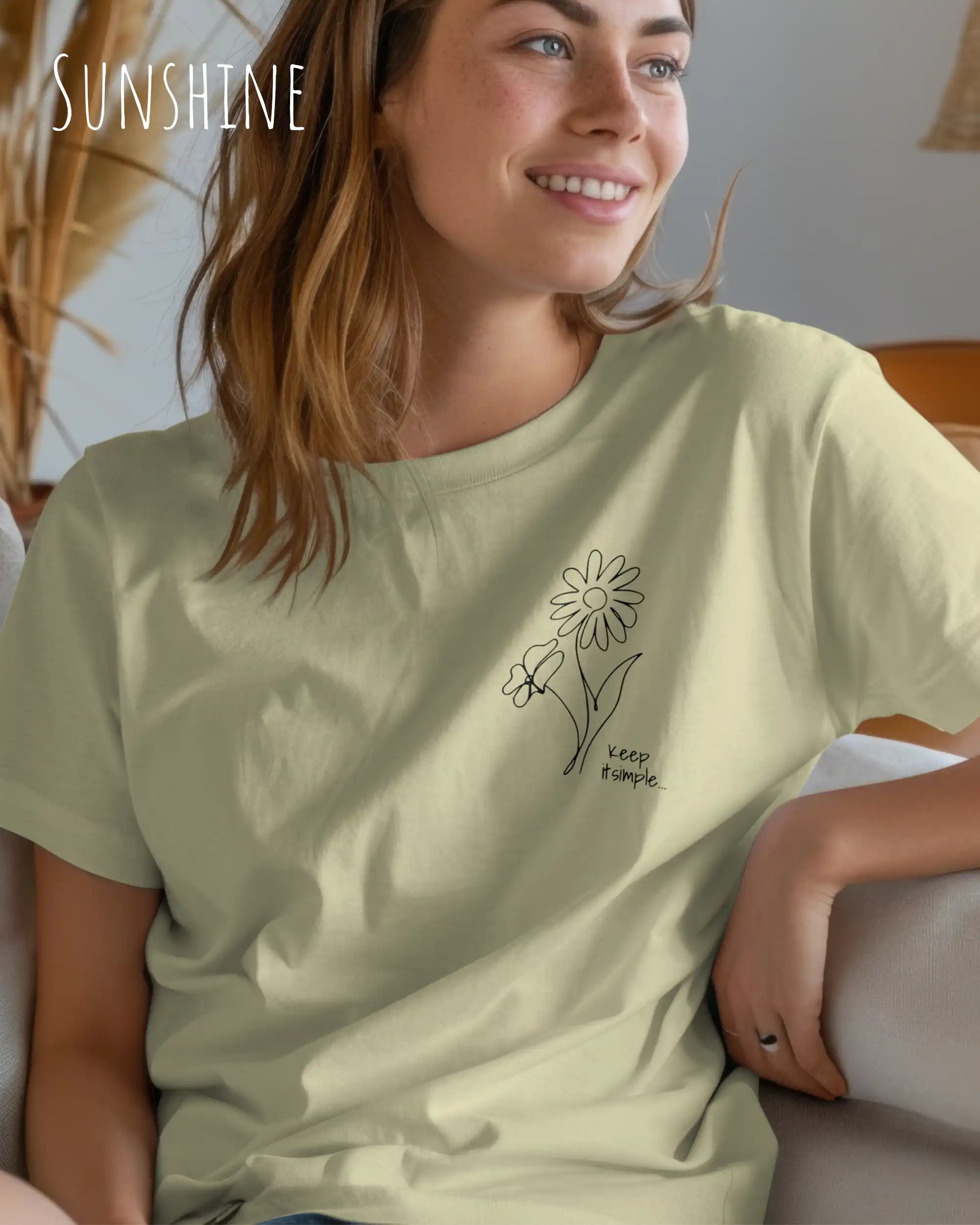 Das Bild zeigt eine junge frau, die ein design-t-shirt ind der farbe sunshine mit dem grafik-motiv keeo it simple trägt.