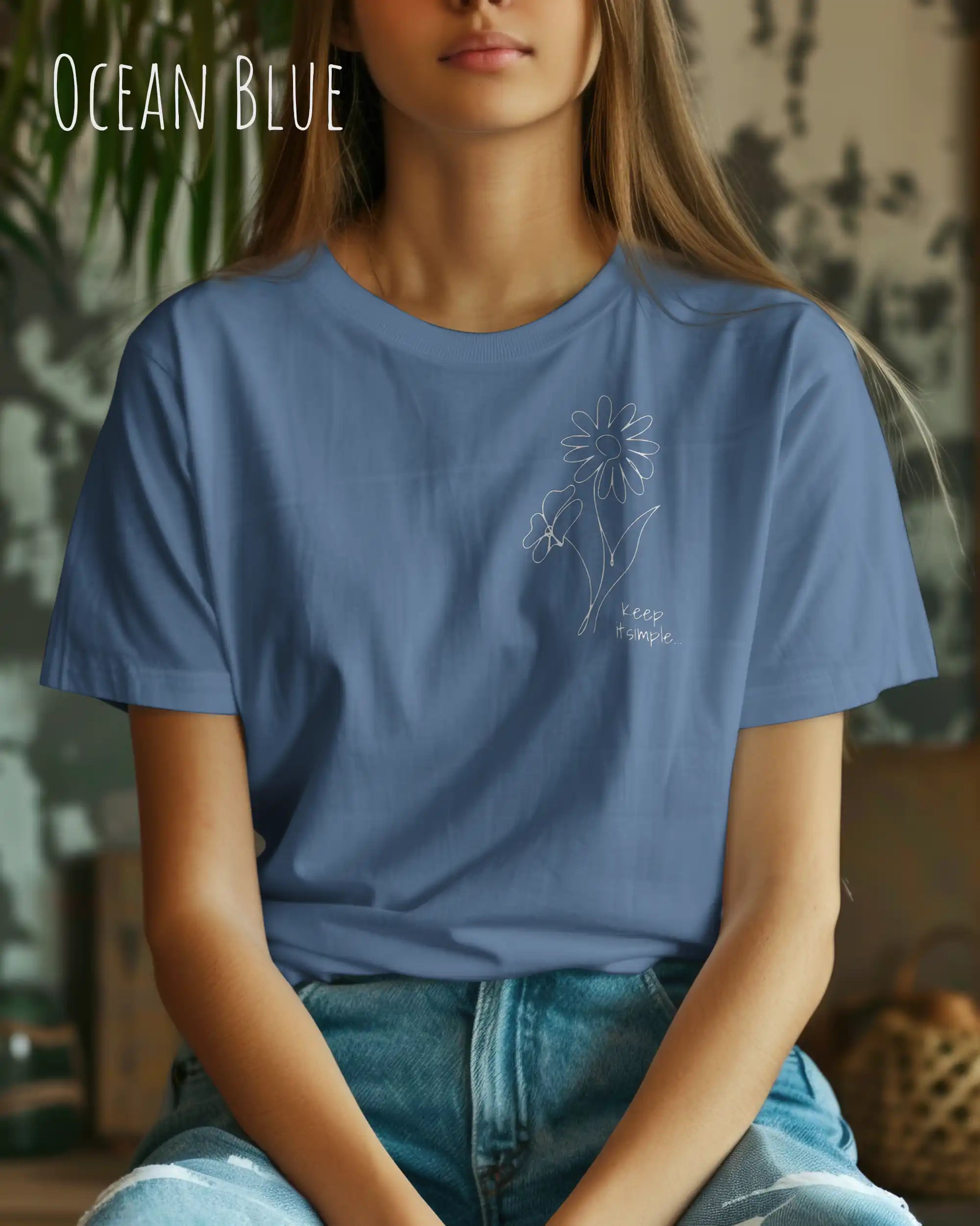junge Frau trägt ein Organic Premium T-Shirt in der Farbe whiteocean blue mit dem Statement-Design keep it simple.