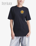 Das Bild zeigt eine frau, die ein Grafik-Design-T-Shirt in der farbe deep black mit dem Design Nothing beats a great smile trägt.