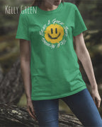 Das Bild zeigt eine frau, die ein Grafik-Design-T-Shirt in der farbe kelly green mit dem Design Nothing beats a great smile trägt.