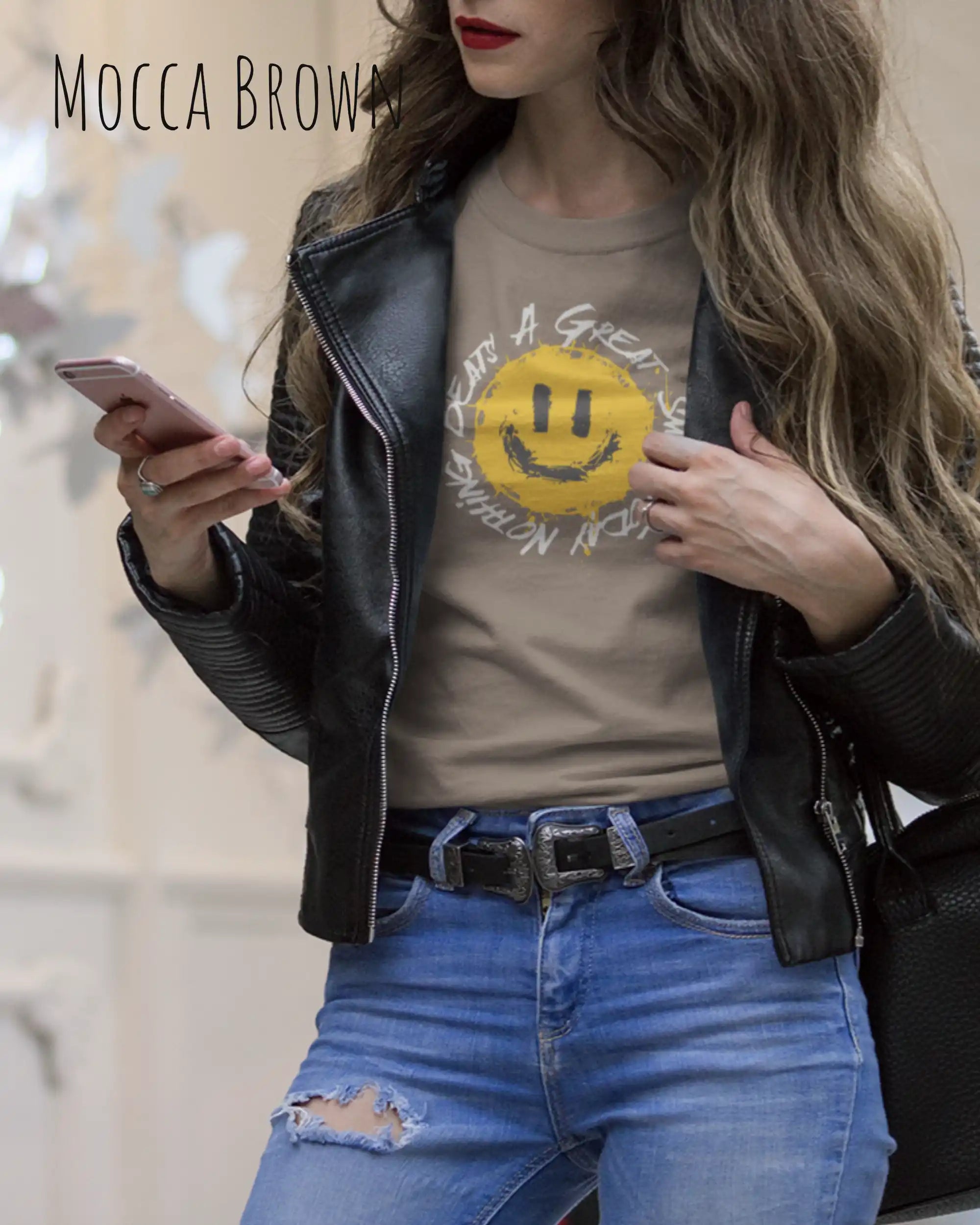 Das Bild zeigt eine frau, die ein Grafik-Design-T-Shirt in der farbe Mocca brown  mit dem Design Nothing beats a great smile trägt.