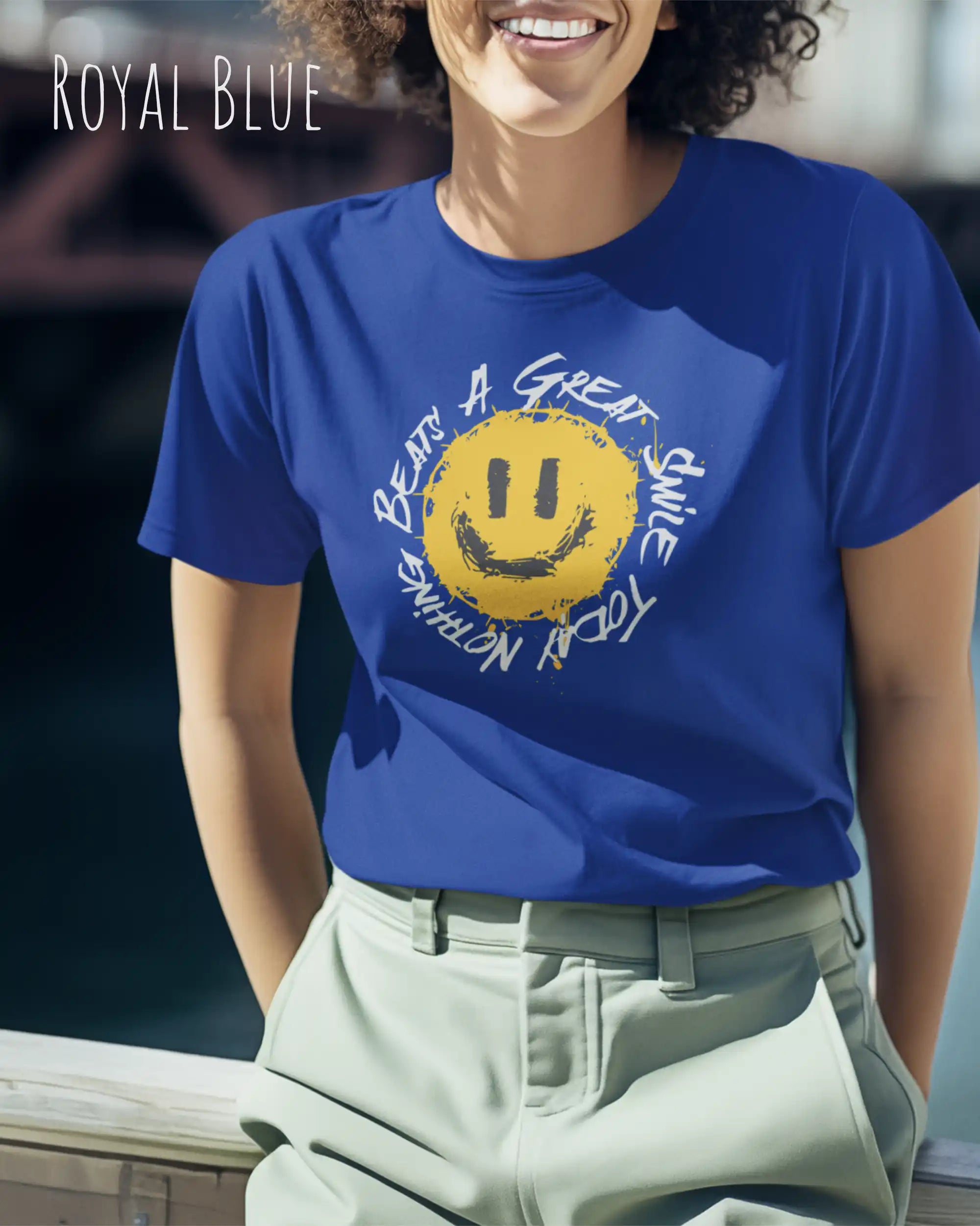 Das Bild zeigt eine frau, die ein Grafik-Design-T-Shirt in der farbe royal blue mit dem Design Nothing beats a great smile trägt.