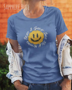 Das Bild zeigt eine frau, die ein Grafik-Design-T-Shirt in der farbe sapphire blue mit dem Design Nothing beats a great smile trägt.