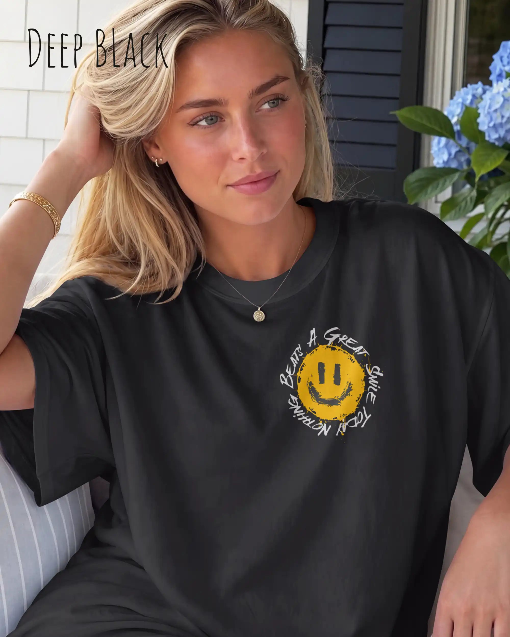 frau trägt ein oversized heavyweight t-shirt  in der farbe deep black   mit dem design nothing beats a great smile today llinks oben