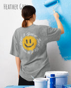 frau trägt ein oversized heavyweight t-shirt  in der farbe heather grey  mit dem design nothing beats a great smile today auf dem rücken.