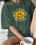 frau trägt ein oversized heavyweight t-shirt  in der farbe moss green  mit dem design nothing beats a great smile today.