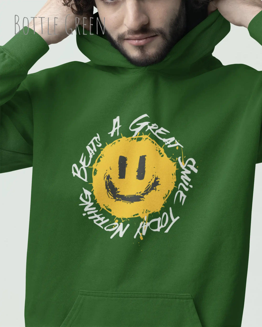 Das Bild zeigt einen mann, der einen Design-Hoodie in der Farbe bottle green und mit der Grafik Nothing beats a great smile trägt.