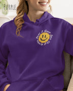 Das Bild zeigt eine Frau, die einen Design-Hoodie in der Farbe üurple und mit der Grafik Nothing beats a great smile links oben trägt.