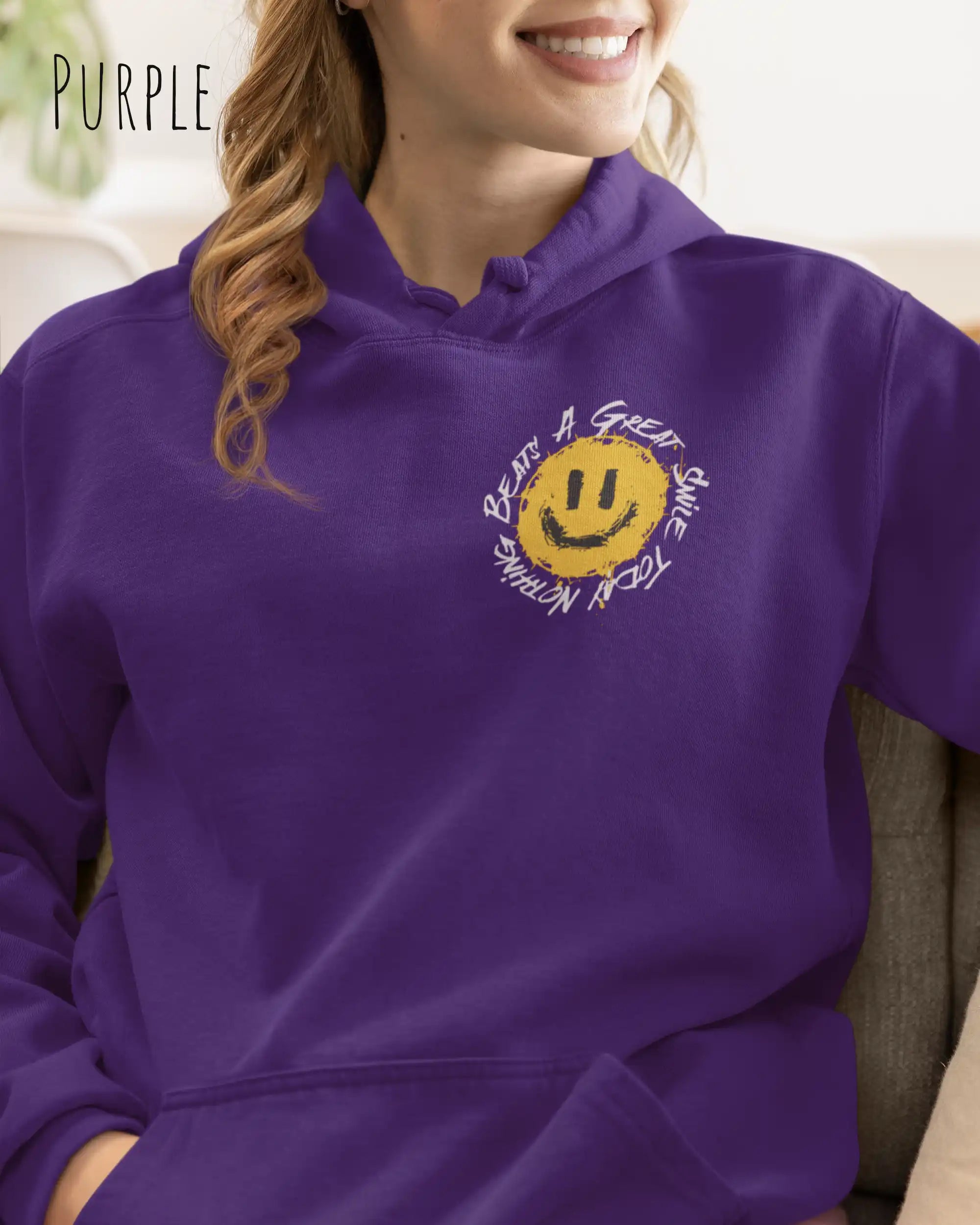 Das Bild zeigt eine Frau, die einen Design-Hoodie in der Farbe üurple und mit der Grafik Nothing beats a great smile links oben trägt.