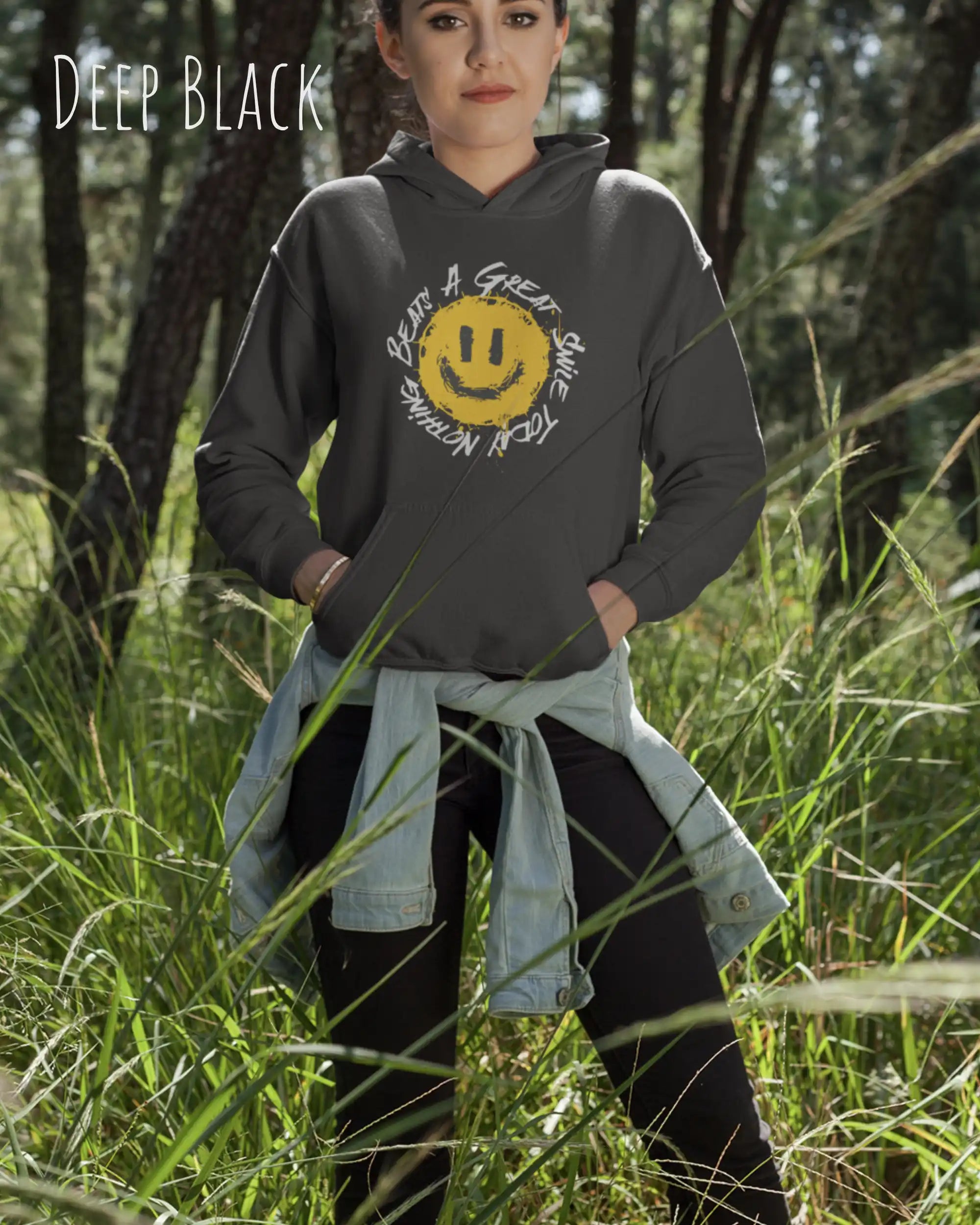 Das Bild zeigt eine frau, die einen  oversized Grafik hoodie in der farbe deep black mit dem design notihing beats a great smile trägt.