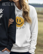 Das Bild zeigt eine frau, die einen  oversized Grafik hoodie in der farbe Arctic white mit dem design notihing beats a great smile trägt.