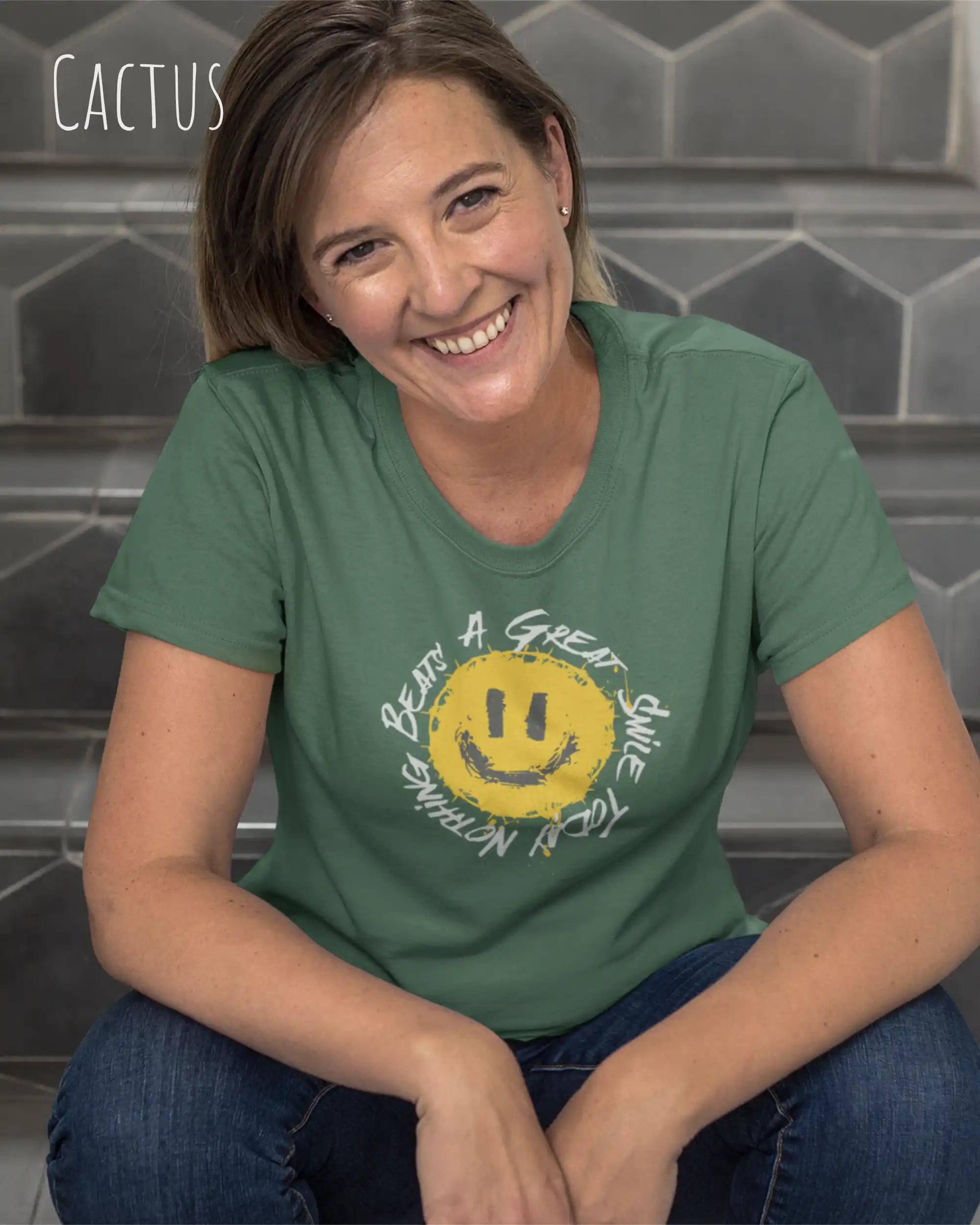 Eine Frau trägt ein Unisex oprganic t-shirt  in der farbe cactus mit dem design  nothing beats a great smile today.