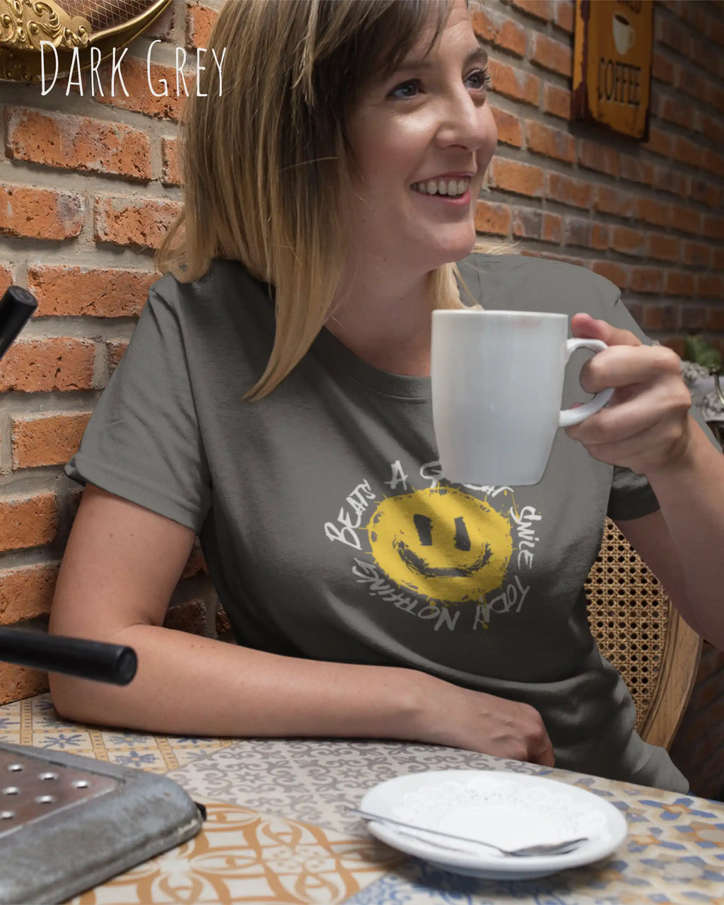 Eine Frau trägt ein Unisex oprganic t-shirt  in der farbe dark grey mit dem design  nothing beats a great smile today.