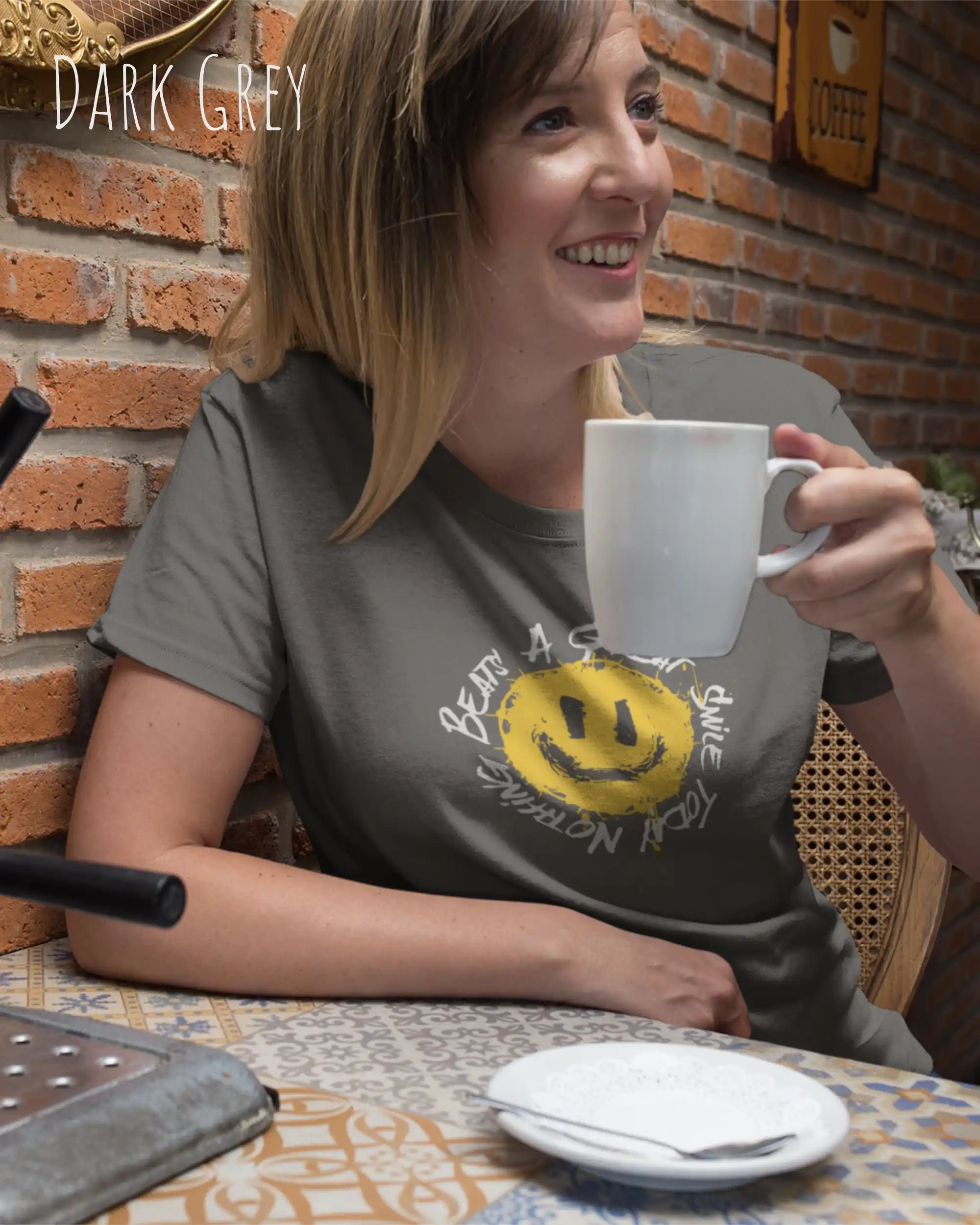 Eine Frau trägt ein Unisex oprganic t-shirt  in der farbe dark grey mit dem design  nothing beats a great smile today.