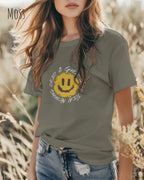 Junge Frau  trägt ein Unisex oprganic t-shirt  in der farbe moss mit dem design  nothing beats a great smile today.
