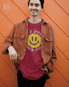 Junger Mann trägt ein Unisex oprganic t-shirt  in der farbe red mit dem design  nothing beats a great smile today.