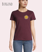 Eine Frau trägt das Basic Design-T‑Shirt im Feminine Fit in der Farbe Burgund.. Das Design zeigt das Statement NOTHING BEATS A SMILE.