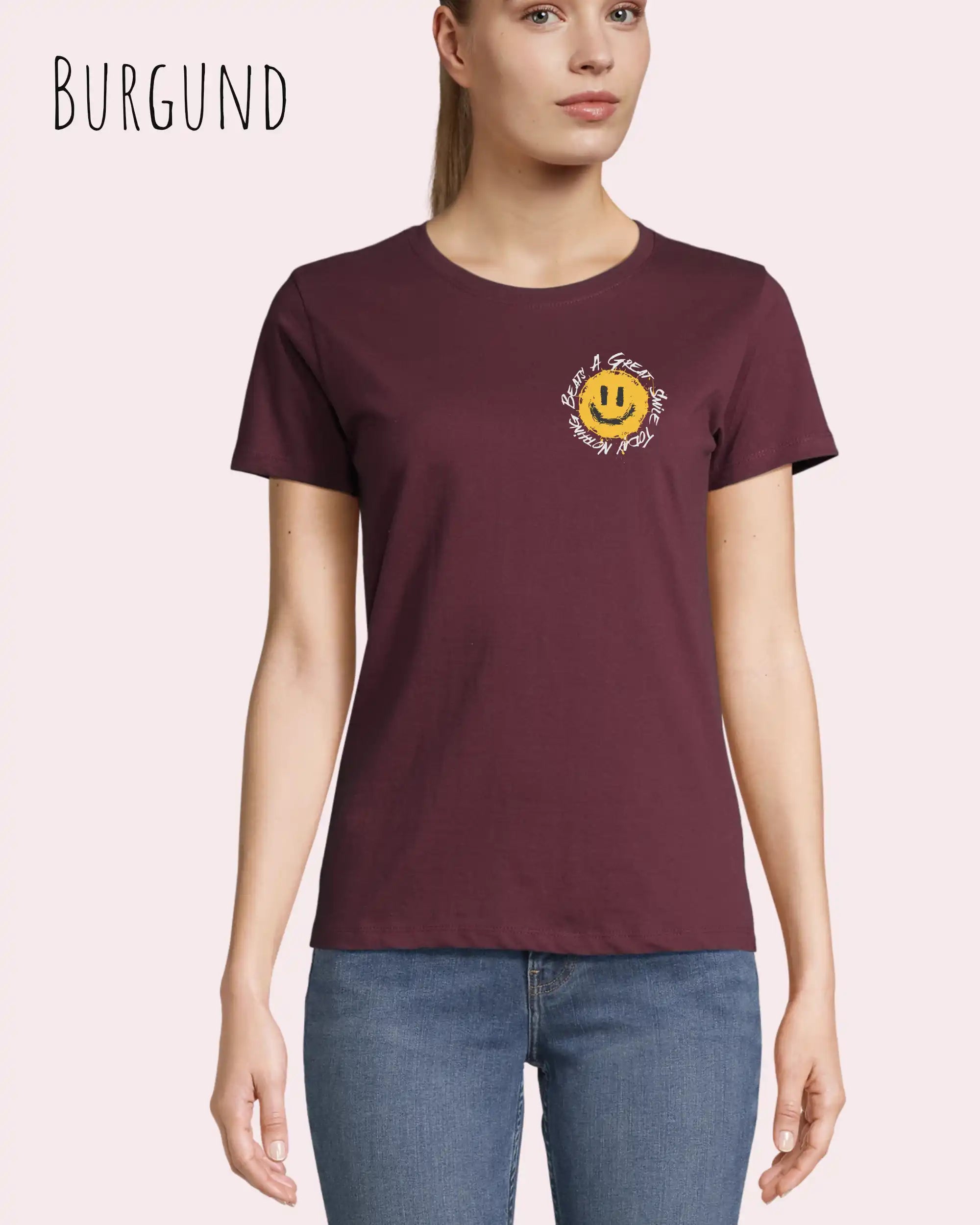 Eine Frau trägt das Basic Design-T‑Shirt im Feminine Fit in der Farbe Burgund.. Das Design zeigt das Statement NOTHING BEATS A SMILE.