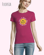 Eine Frau trägt das Basic Design-T‑Shirt im Feminine Fit in der Farbe fuchsia.. Das Design zeigt das Statement NOTHING BEATS A SMILE.