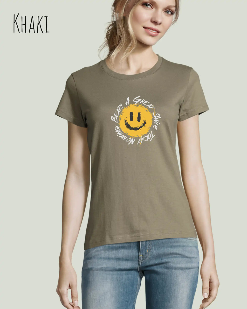 Eine Frau trägt das Basic Design-T‑Shirt im Feminine Fit in der Farbe khaki.. Das Design zeigt das Statement NOTHING BEATS A SMILE.