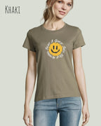 Eine Frau trägt das Basic Design-T‑Shirt im Feminine Fit in der Farbe khaki.. Das Design zeigt das Statement NOTHING BEATS A SMILE.