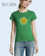 Eine Frau trägt das Basic Design-T‑Shirt im Feminine Fit in der Farbe Kelly green.. Das Design zeigt das Statement NOTHING BEATS A SMILE.