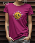 Eine Frau trägt ein Design-T‑Shirt im Feminine Fit in der Farbe fuchsia. Das Design zeigt das Statement NOTHING BEATS A SMILE.