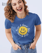 Lachende Frau trägt ein Design-T‑Shirt im Feminine Fit in der Farbe royal blue. Das Design zeigt das Statement NOTHING BEATS A SMILE.