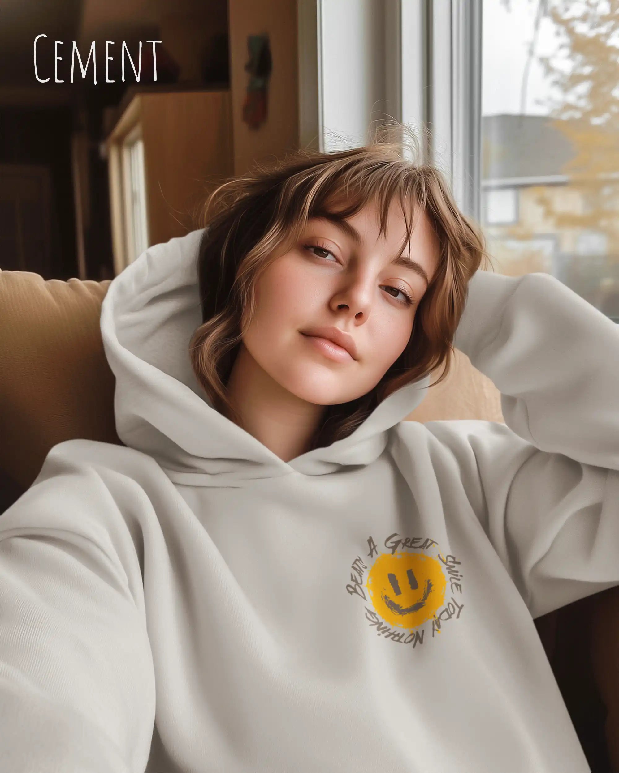 Frau trägt einen Heavyweight oversized Hoodie in der Farbe Cement mit dem Statement-Design Nothing beats a great smile today.