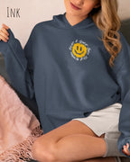 Frau trägt einen Heavyweight oversized Hoodie in Ink mit dem Statement-Design Nothing beats a great smile today.
