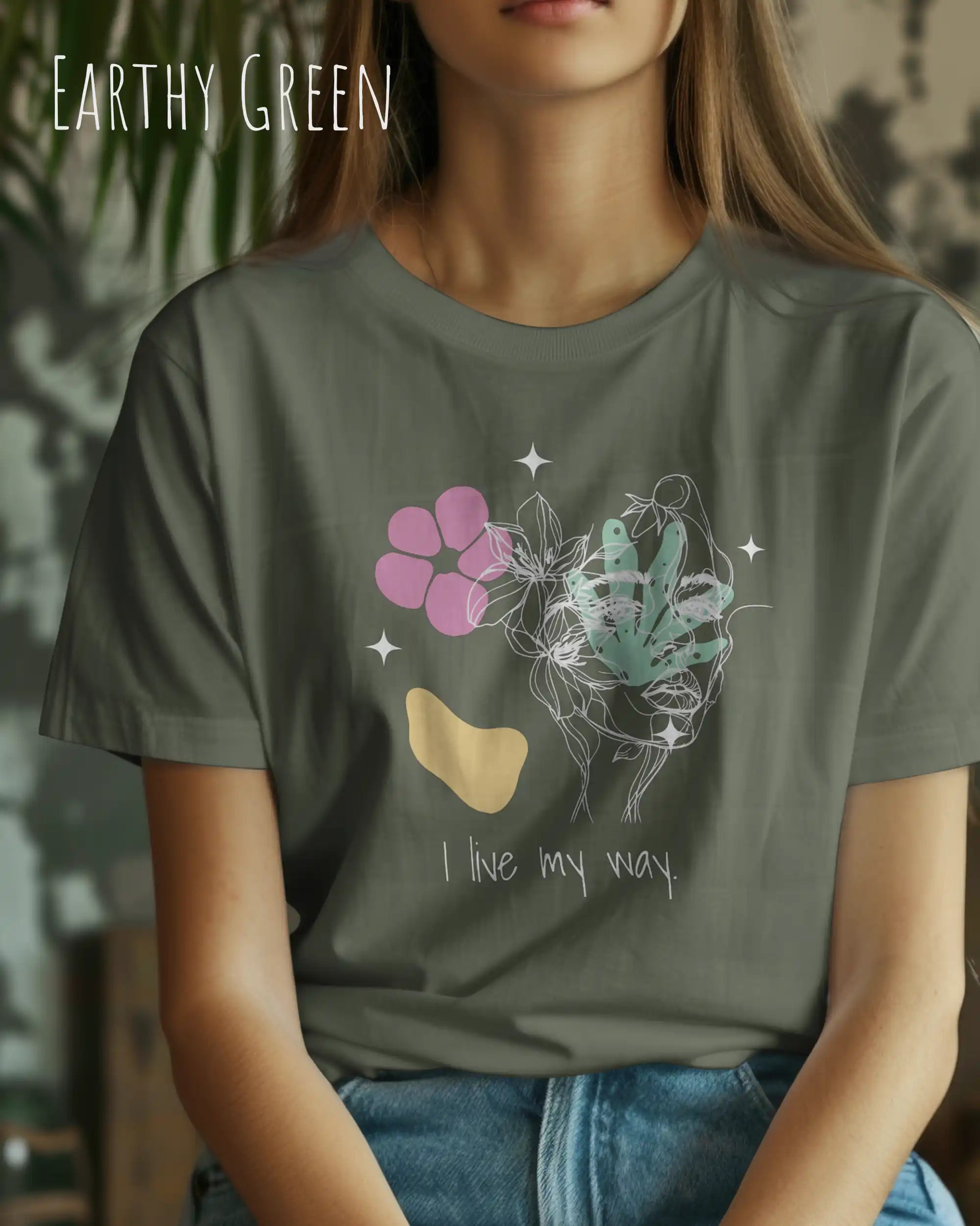 Eine Frau trägt ein Design-T-Shirt in der farbe EARTHY GREEN aus atmungsaktiver Baumwolle  mit dem statement I live my way.