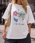 Frau trägt ein oversized heavyweight ndesign-t-shirt in der farbe arctic white  und mit  dem motiv I live my way vorneauf der brust