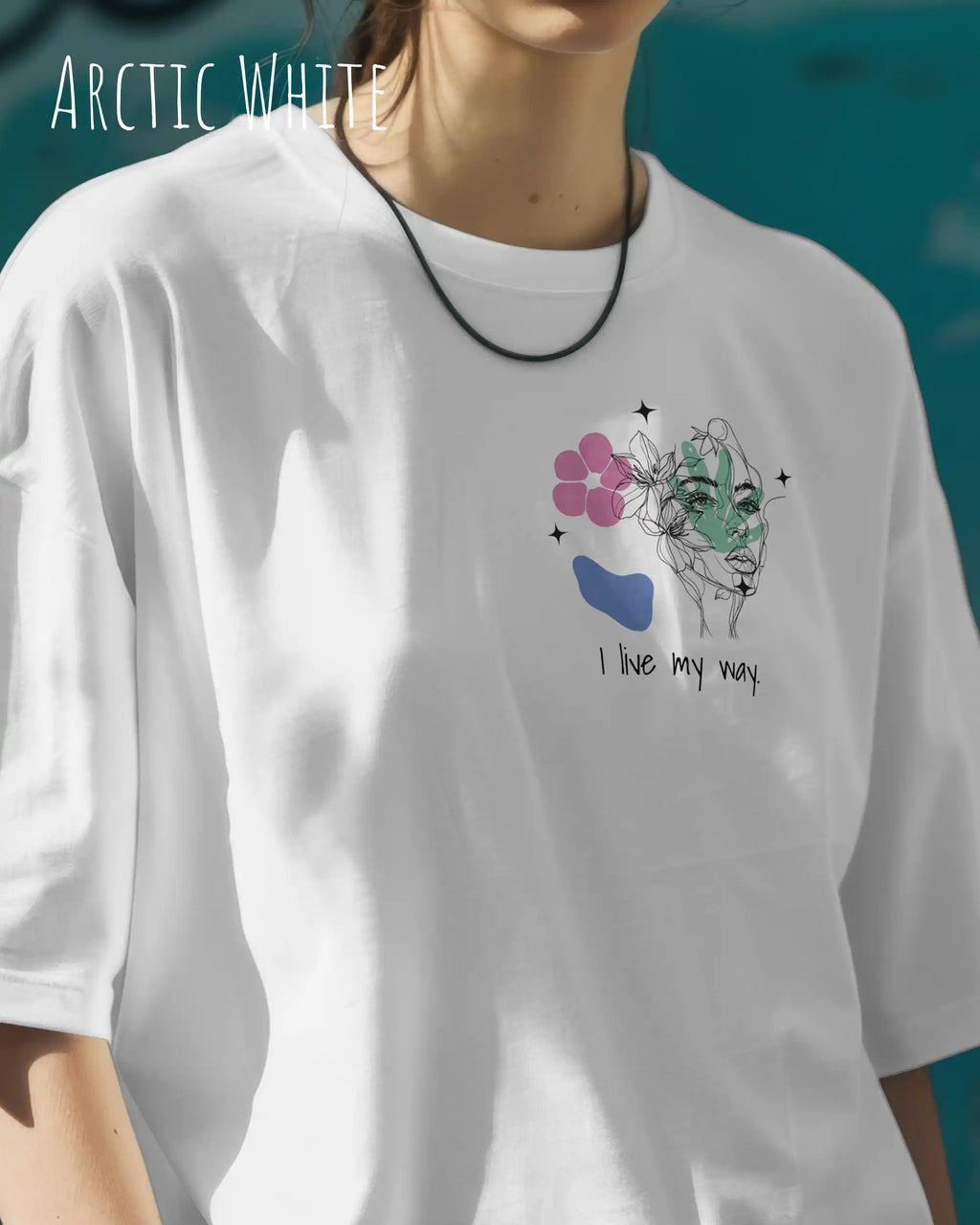 Frau trägt ein oversized heavyweight ndesign-t-shirt in der farbe arctic white und mit  dem motiv I live my way links oben,