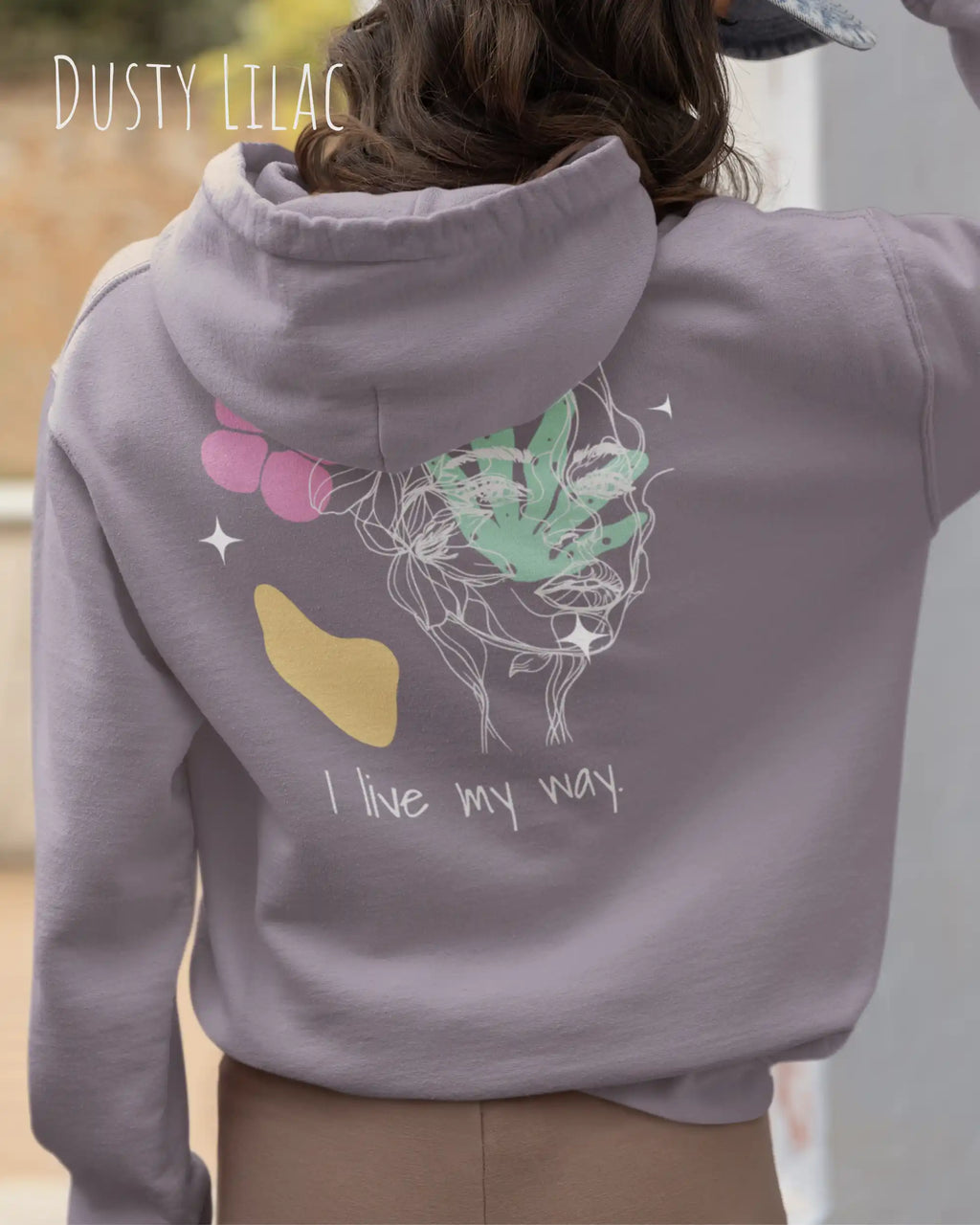 Frau trägt einen Oversized Design-Hoodie 
in der Farbe DUSTY LILAC mit dem Statement I LIVE MY WAY.AUF DEM RÜCKEN.