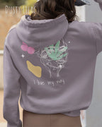 Frau trägt einen Oversized Design-Hoodie 
in der Farbe DUSTY LILAC mit dem Statement I LIVE MY WAY.AUF DEM RÜCKEN.