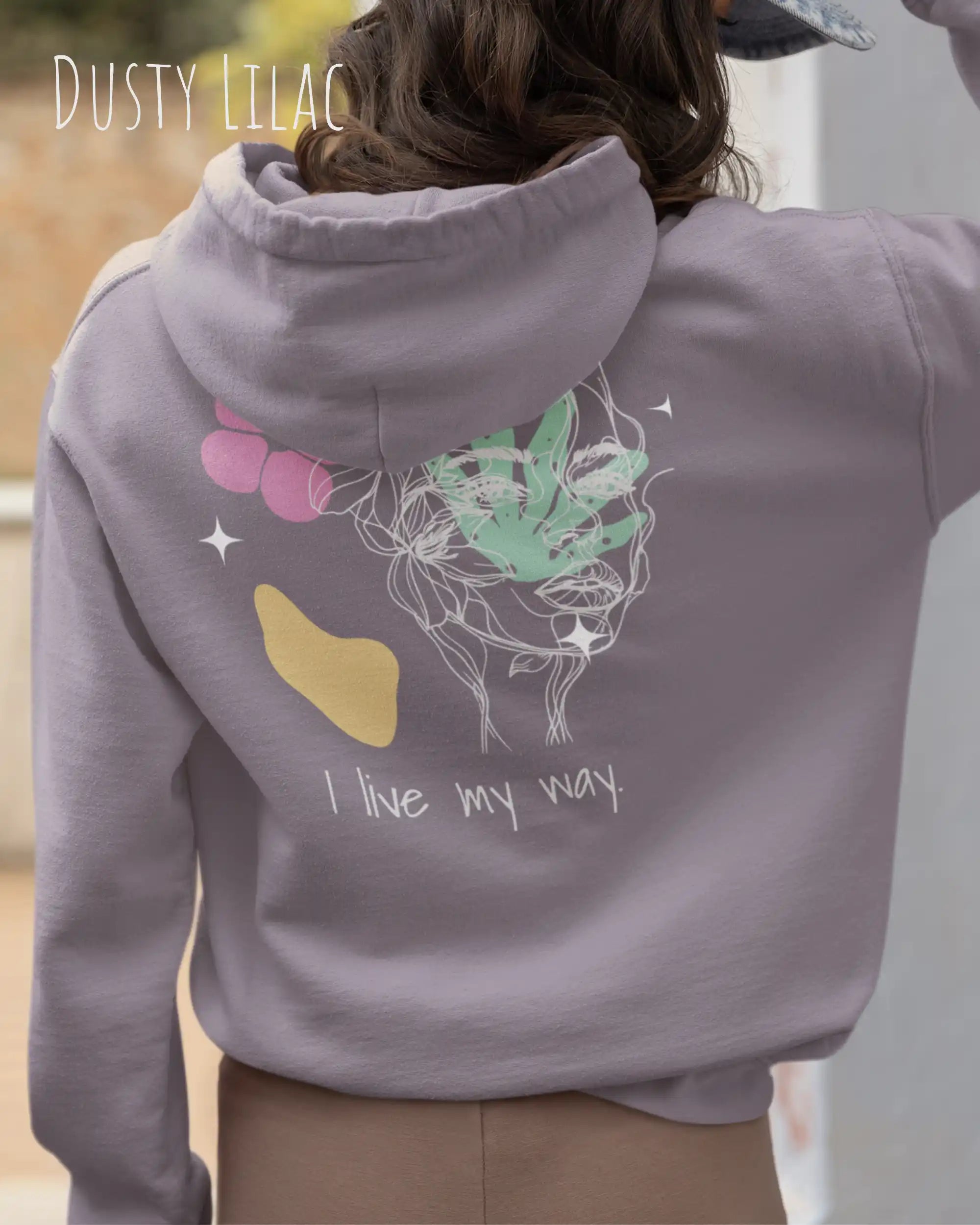 Frau trägt einen Oversized Design-Hoodie 
in der Farbe DUSTY LILAC mit dem Statement I LIVE MY WAY.AUF DEM RÜCKEN.