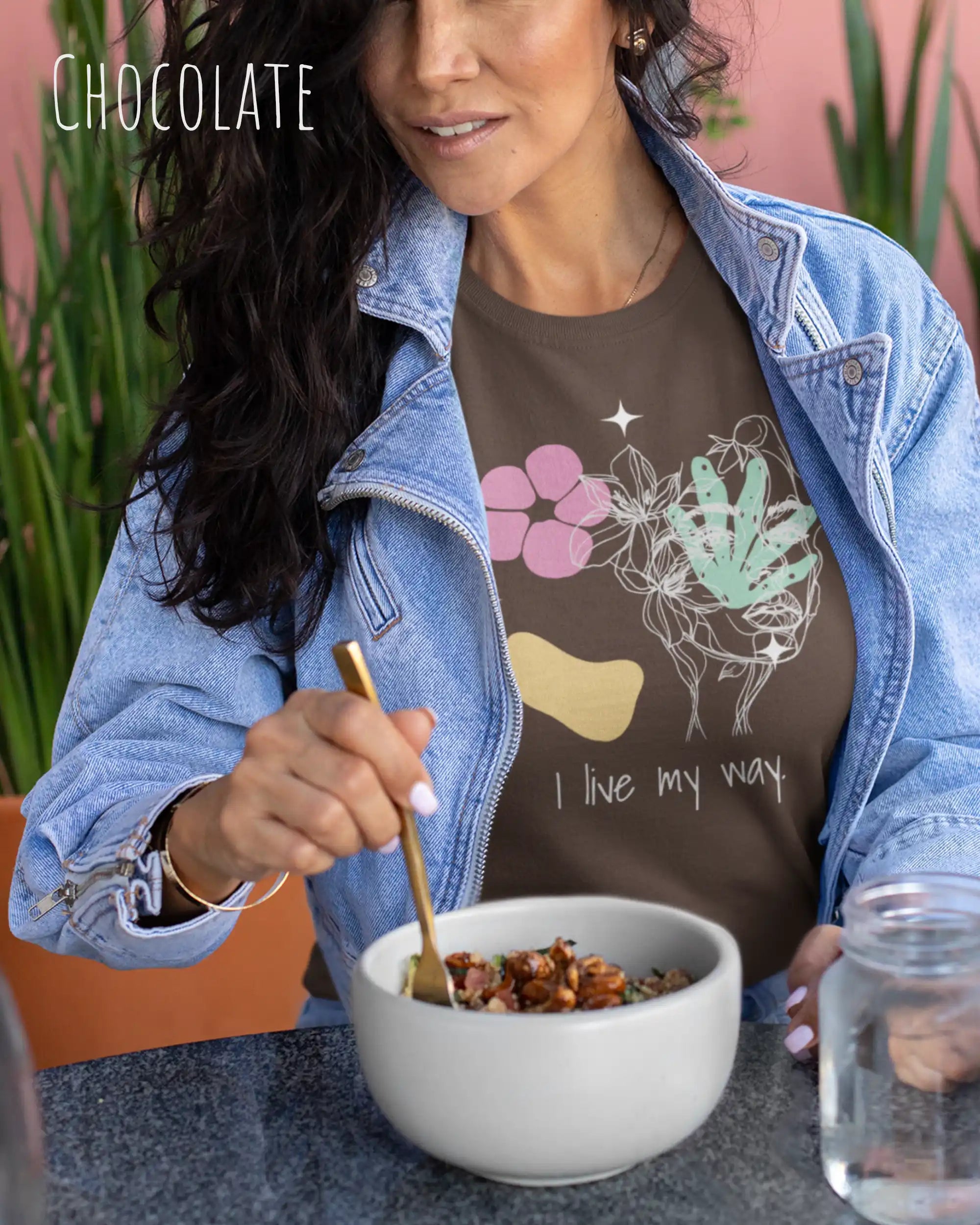 Eine Frau trägt ein Basic Design-T-Shirt mit femininem Fit in der Farbe chocolate und mit dem Statement I live my way.