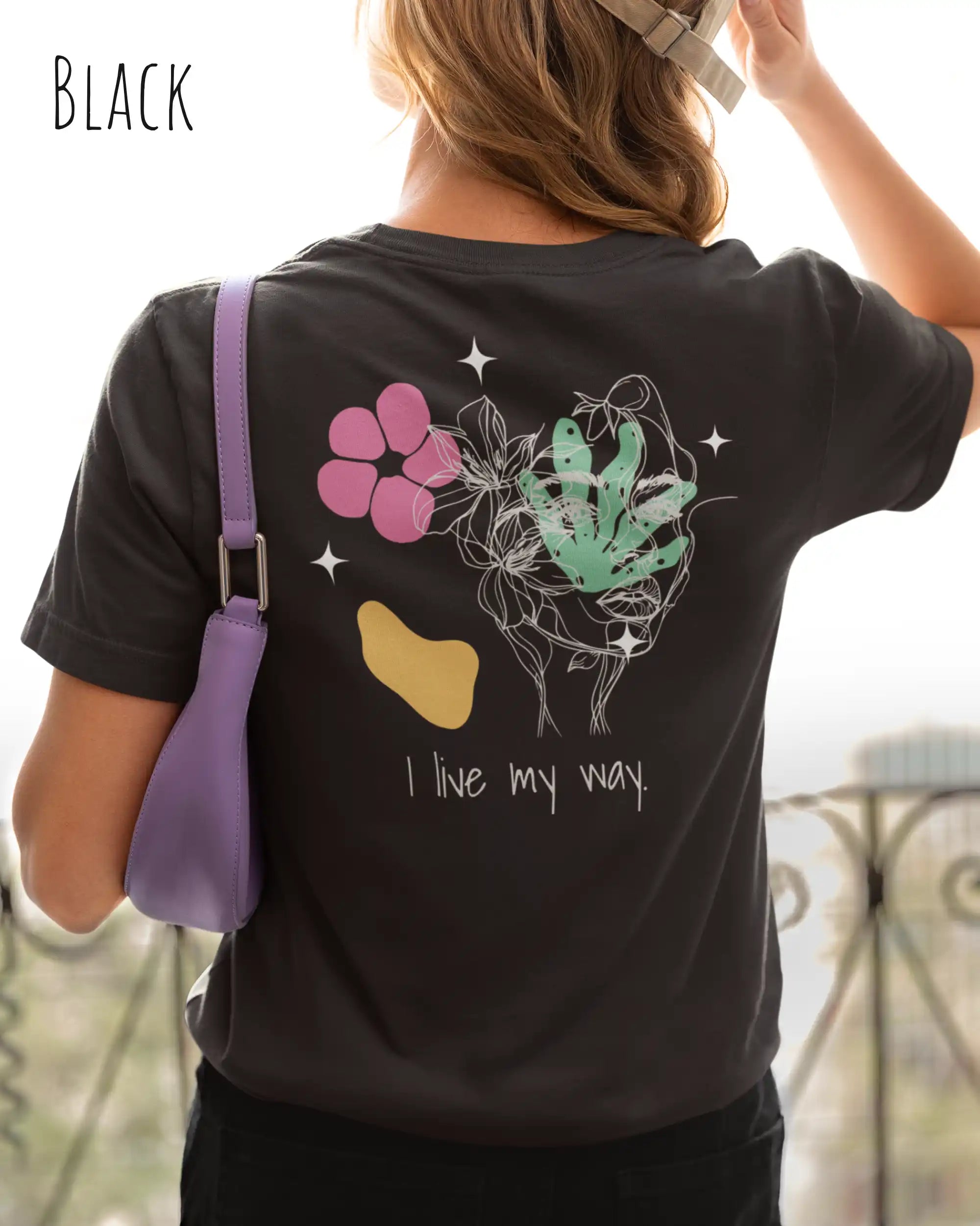 junge frau trägt ein nachhaltige Bio-Design-T-Shirt  in der Farbe black mit dem Statement-Motiv "I live my Way".
