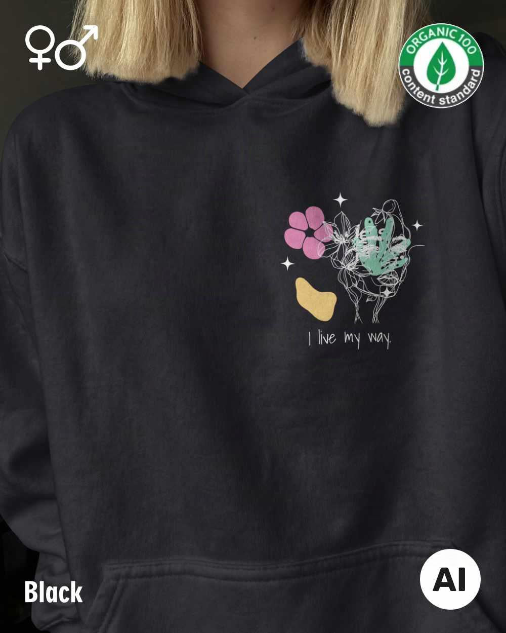 eine frau trägt einen Premium Design-Hoodie aus 100% Bio-Baumwolle in der farbe black mit dem motiv "i live my way" vorne oben links.