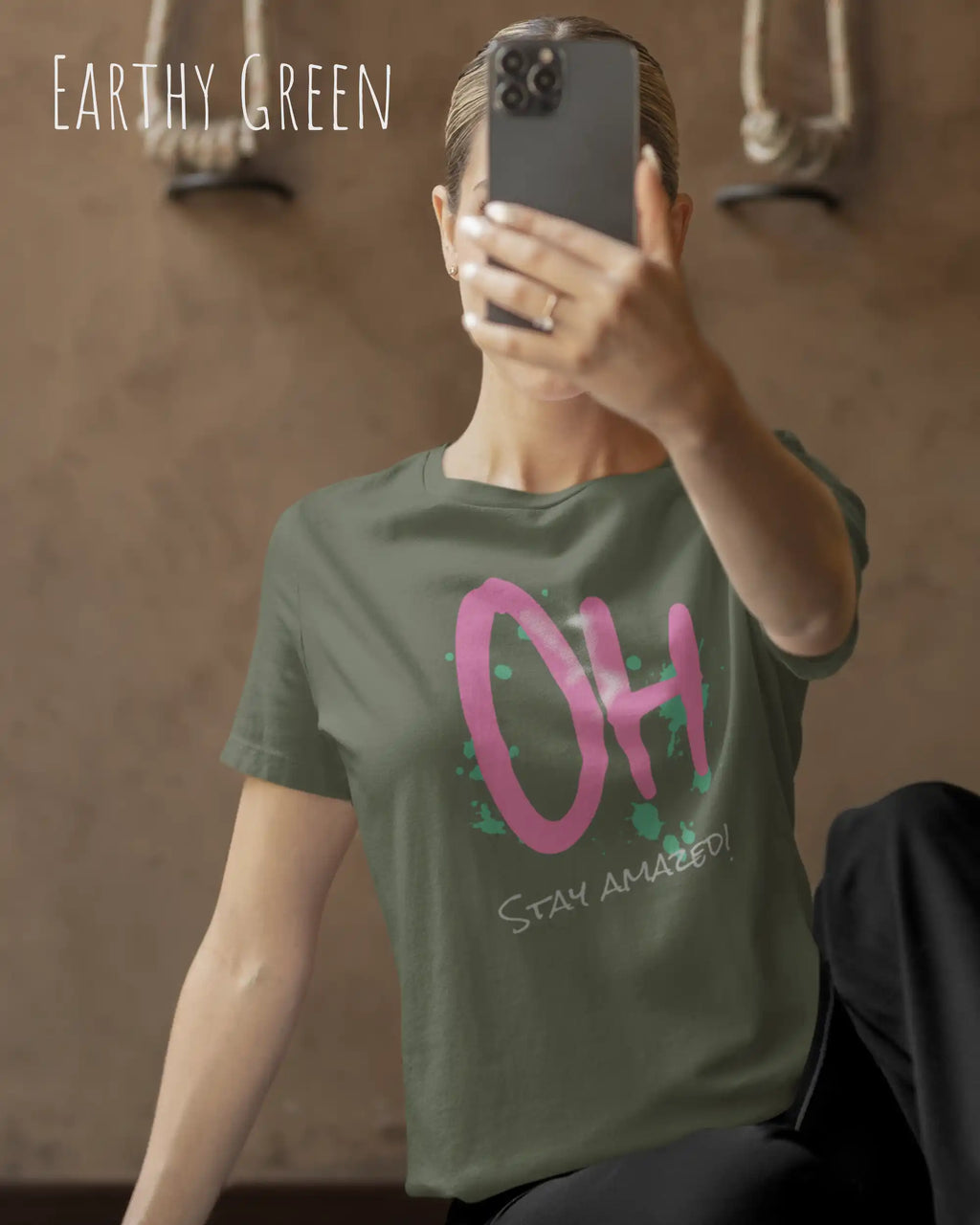 Frau trägt das leichte Sommer T-Shirt aus Baumwolle AWDis 150 T in der Farbe EARTHY GREEN mit dem Design STAY AMAZED auf der Brust.