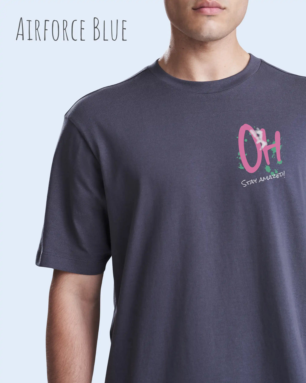 Mann trägt das leichte Sommer T-Shirt aus Baumwolle AWDis 150 T in der Farbe Airforce Blue mit dem Design STAY AMAZED links oben auf der Brust.