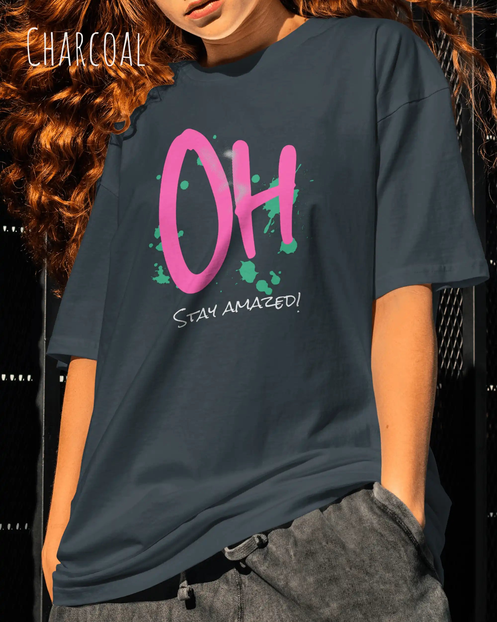 Mann trägt das Heavyweight Oversized T-Frau AWDis 240 T in der Farbe charcoal  mit dem Design OH STAY AMAZED auf der Brust.