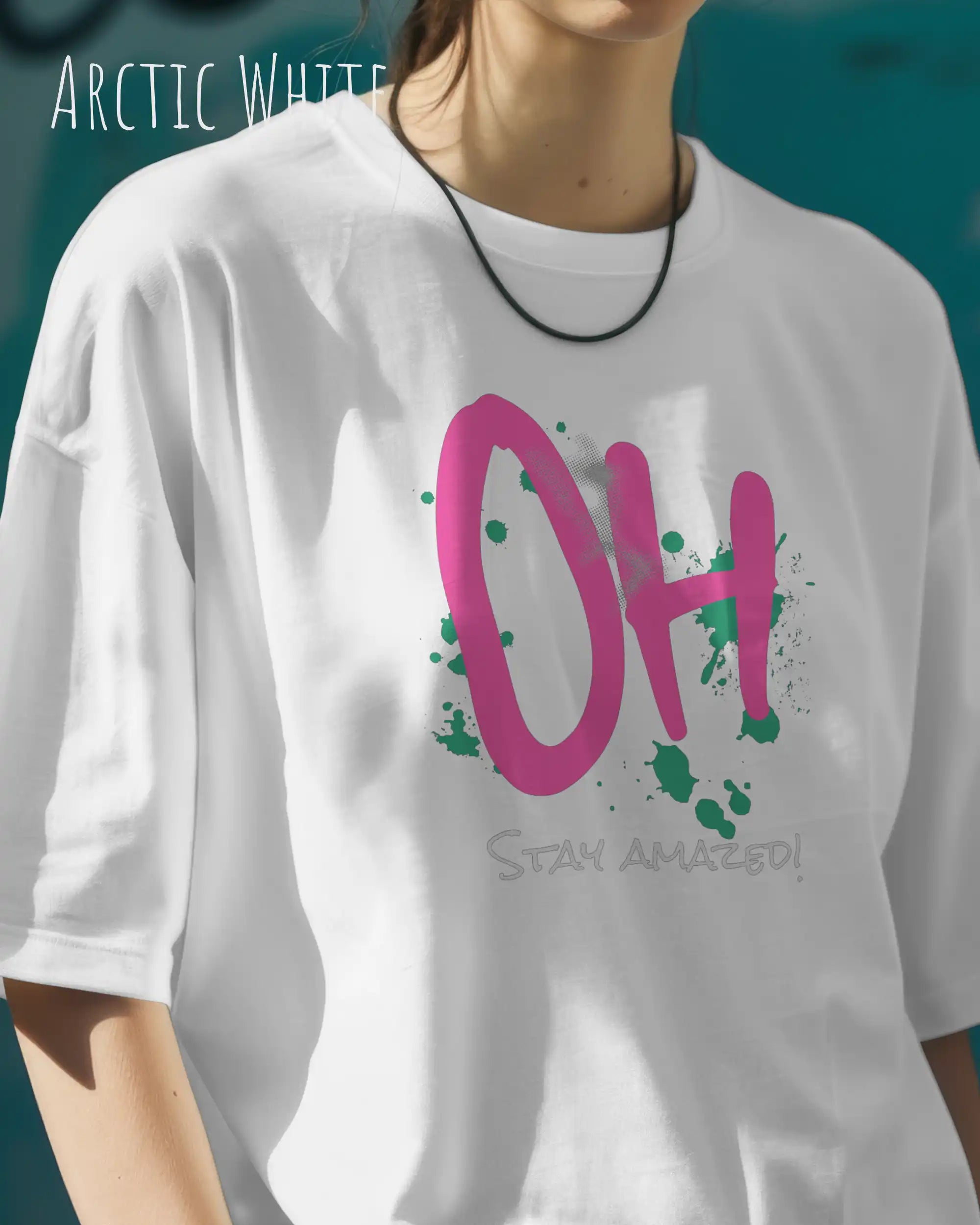 Frau trägt das Heavyweight Oversized T-Shirt AWDis 240 T in der Farbe arctic white mit dem Design OH STAY AMAZED auf der Brust.